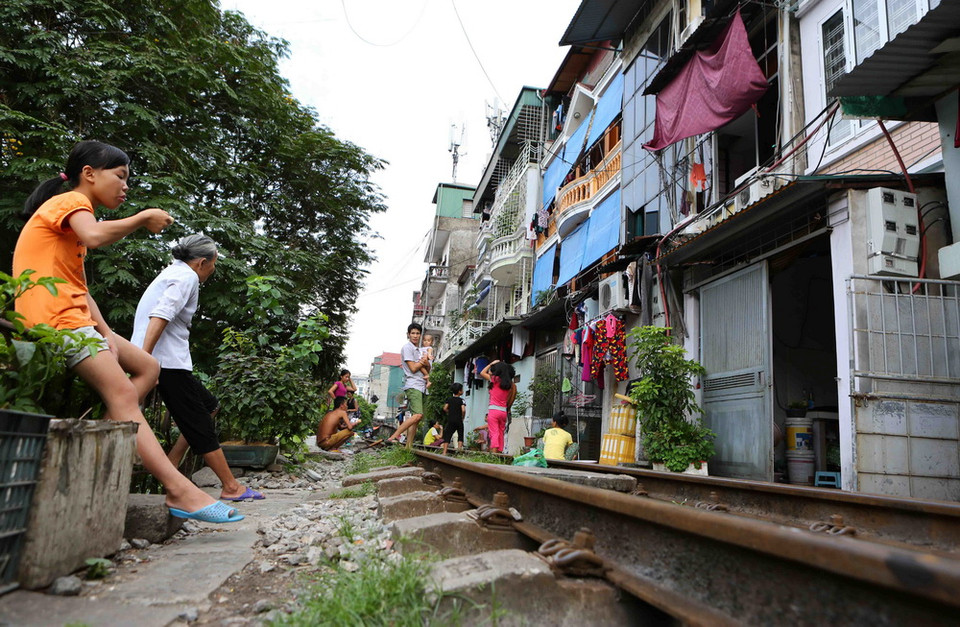 Cuộc sống và làm việc thường ngày của các hộ dân sống ngay trên đường tàu chạy qua. (Ảnh: Thành Đạt/TTXVN)