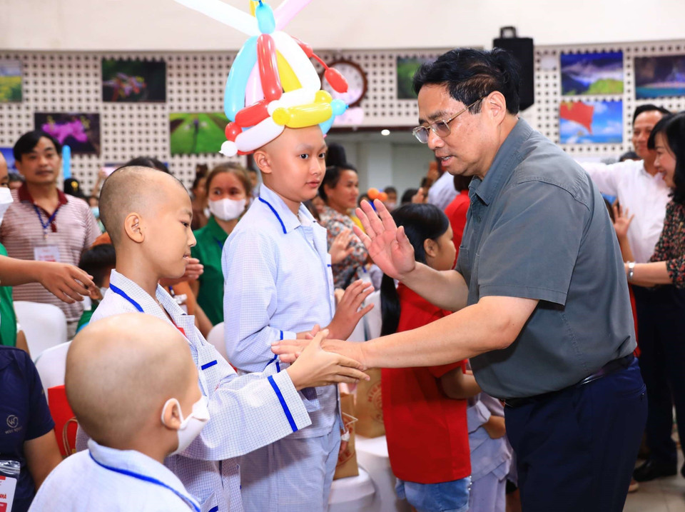 Thủ tướng Phạm Minh Chính thăm hỏi, động viên các bệnh nhi và người thân. (Ảnh: Hoàng Hiếu/TTXVN)