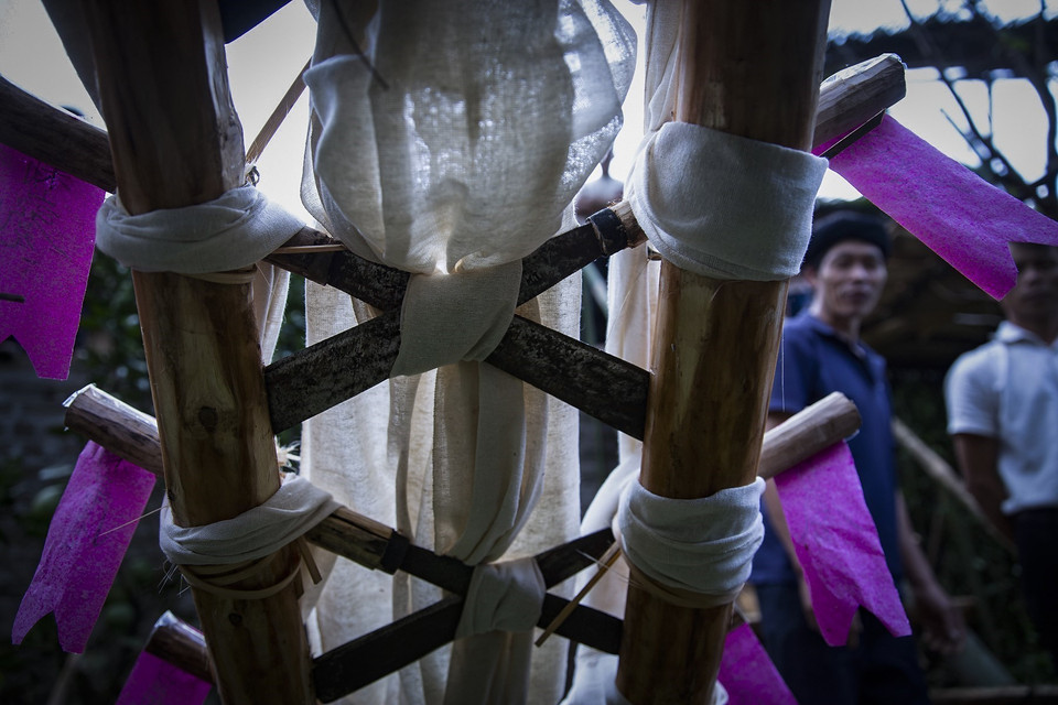 Chiếc thang đặc biệt để lên đàn tế được làm bằng các lưỡi dao quắm đặt chéo nhau. Tổng cộng có 13 lưỡi dao, lưỡi trên cùng đặt ngang, 12 lưỡi còn lại bắt chéo, phần mũi cắm vào thân gỗ cầu thang, phần cán dao buộc lại bằng vải trắng. (Ảnh: Trọng Đạt/TTXVN)