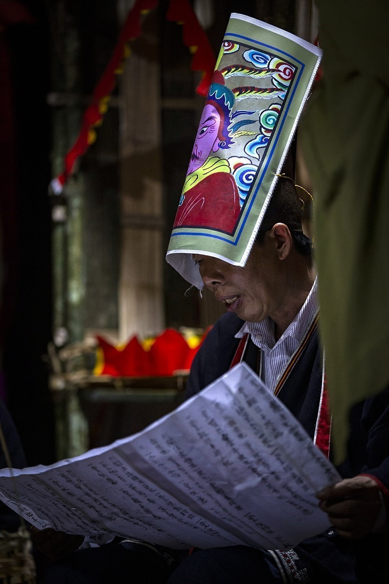 Thầy cúng đọc sớ tấu lên thiên đình để giải oan, cầu siêu cho linh hồn những người quá cố trong Lễ “Đám chay.” (Ảnh: Trọng Đạt/TTXVN)