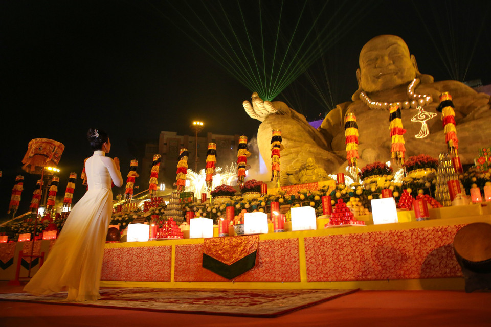 Cầu an trước tượng Phật Di Lặc. (Ảnh: Giang Phương/TTXVN)