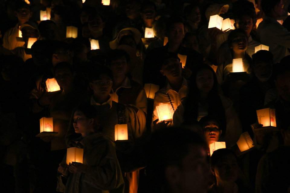 Các phật tử làm nghi thức dâng hoa đăng để cầu an. (Ảnh: Giang Phương/TTXVN)