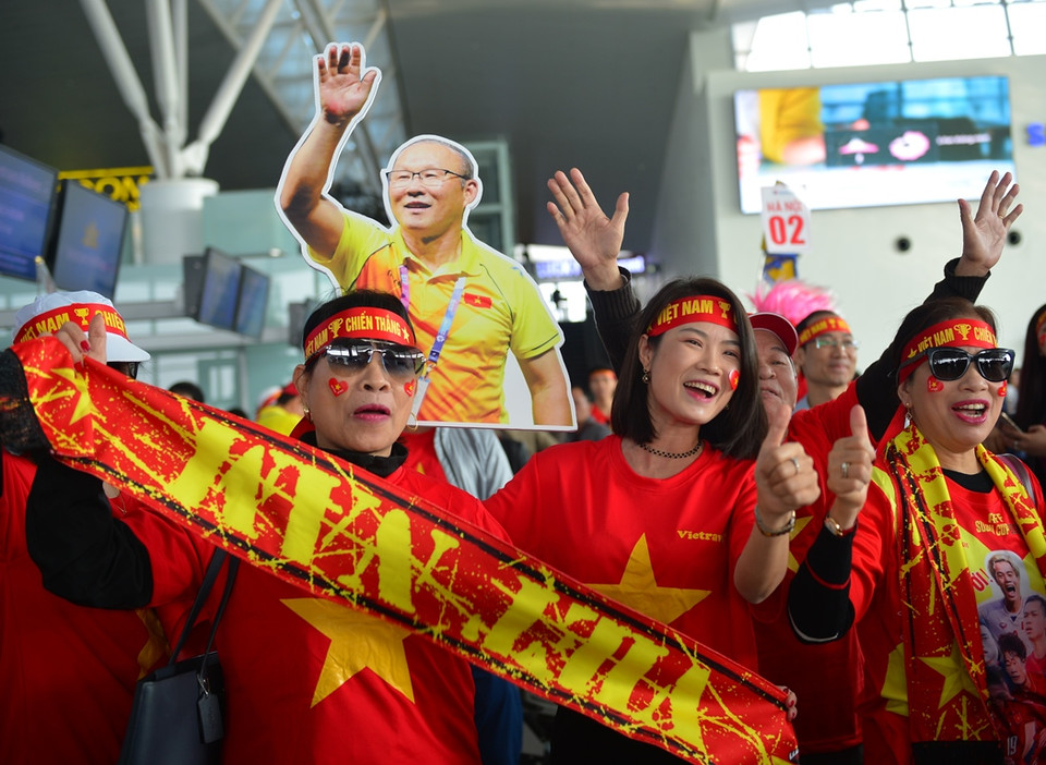 Cổ động viên nhuốm màu đỏ trên sân bay quốc tế Nội Bài. (Ảnh: CTV/Vietnam+)