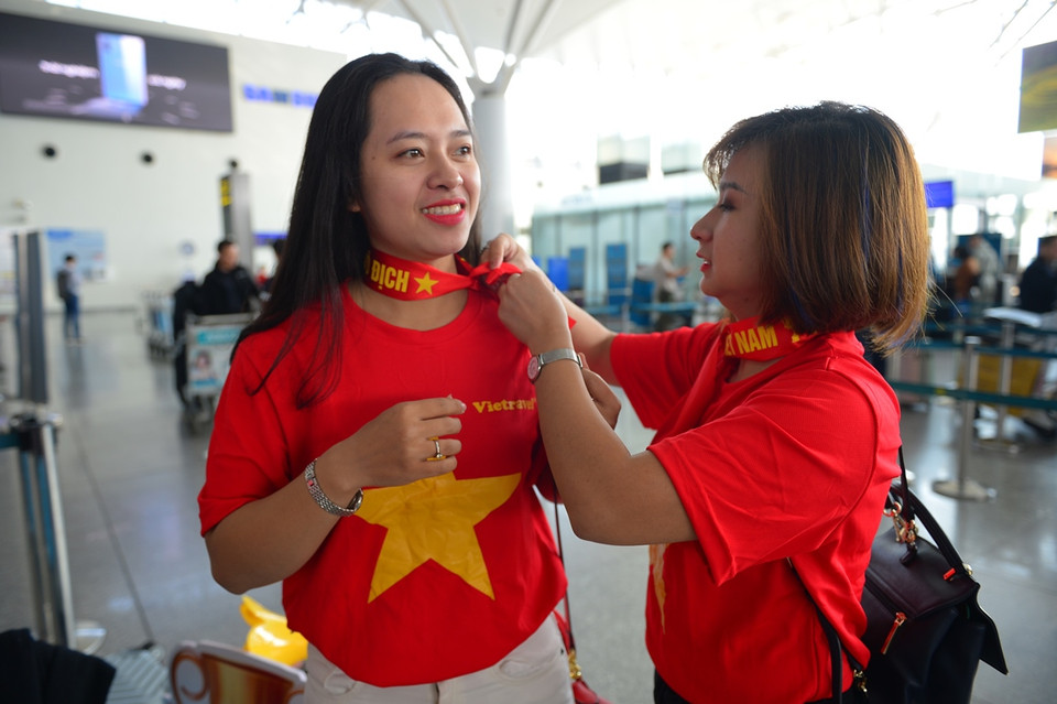 Buộc nơ có màu cờ đỏ Tổ quốc trên cổ để đồng hành cùng đội tuyển U22 đá chung kết. (Ảnh: CTV/Vietnam+)