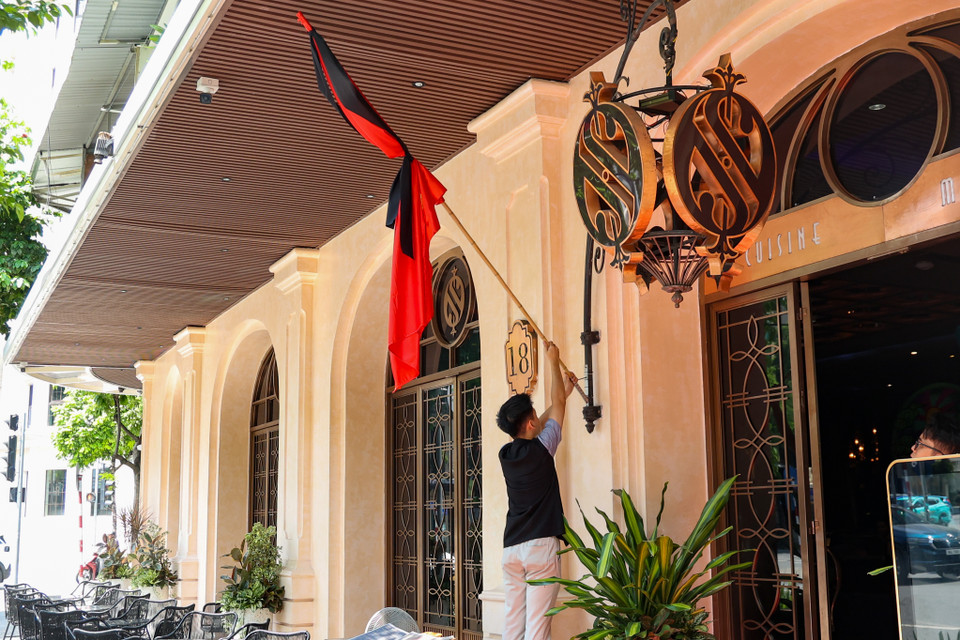 Một đơn vị kinh doanh trên phố Hai Bà Trưng đang treo cờ rủ để tưởng nhớ Tổng Bí thư Nguyễn Phú Trọng. (Ảnh: Minh Hiếu/Vietnam+)