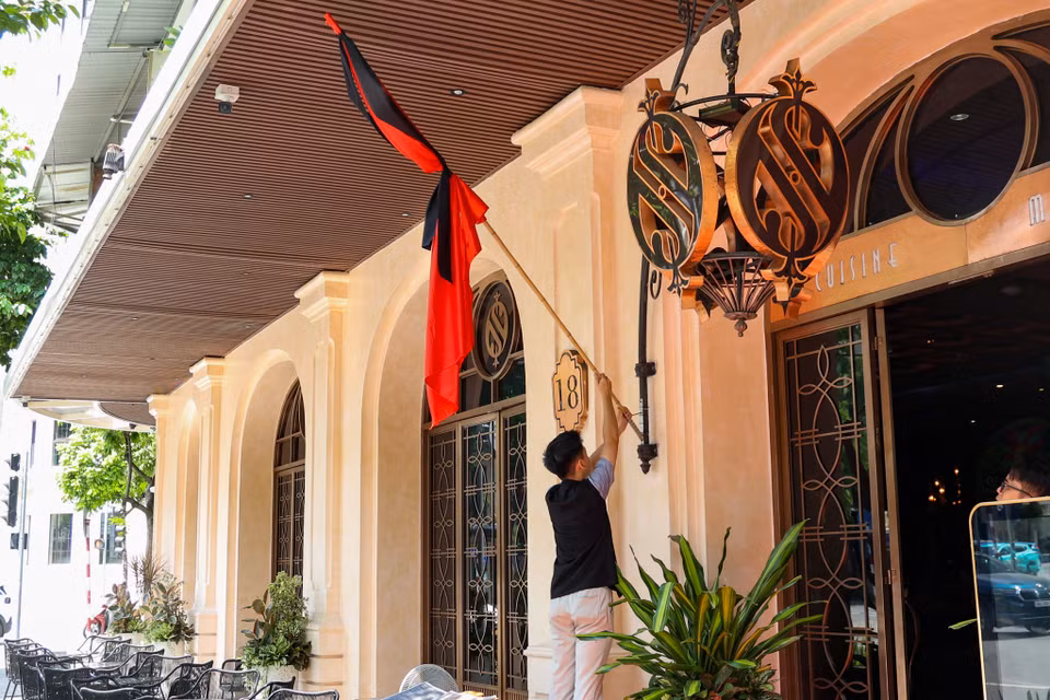 Một đơn vị kinh doanh trên phố Hai Bà Trưng đang treo cờ rủ để tưởng nhớ Tổng Bí thư Nguyễn Phú Trọng. (Ảnh: Minh Hiếu/Vietnam+)