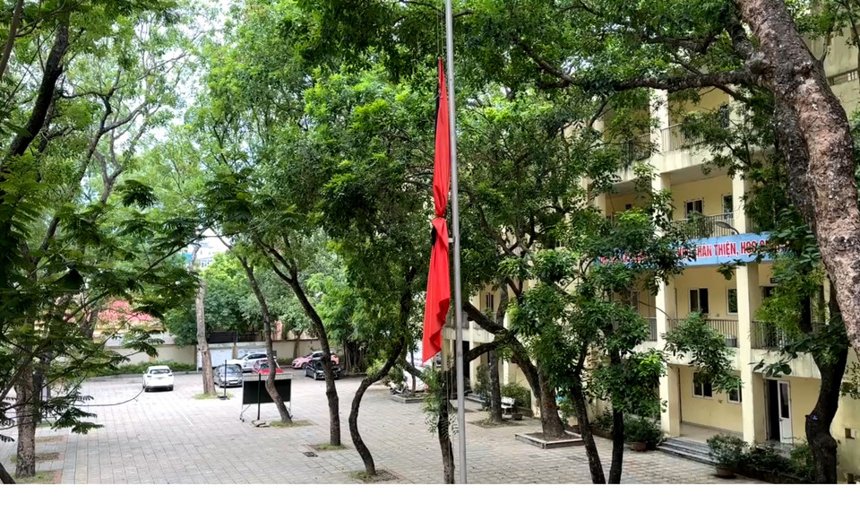 Lá cờ rủ treo trang trọng trên chính giữa sân trường Trung học phổ thông Nguyễn Gia Thiều (quận Long Biên) - nơi Tổng Bí thư Nguyễn Phú Trọng đã từng theo học. (Ảnh: Minh Hiếu/Vietnam+)