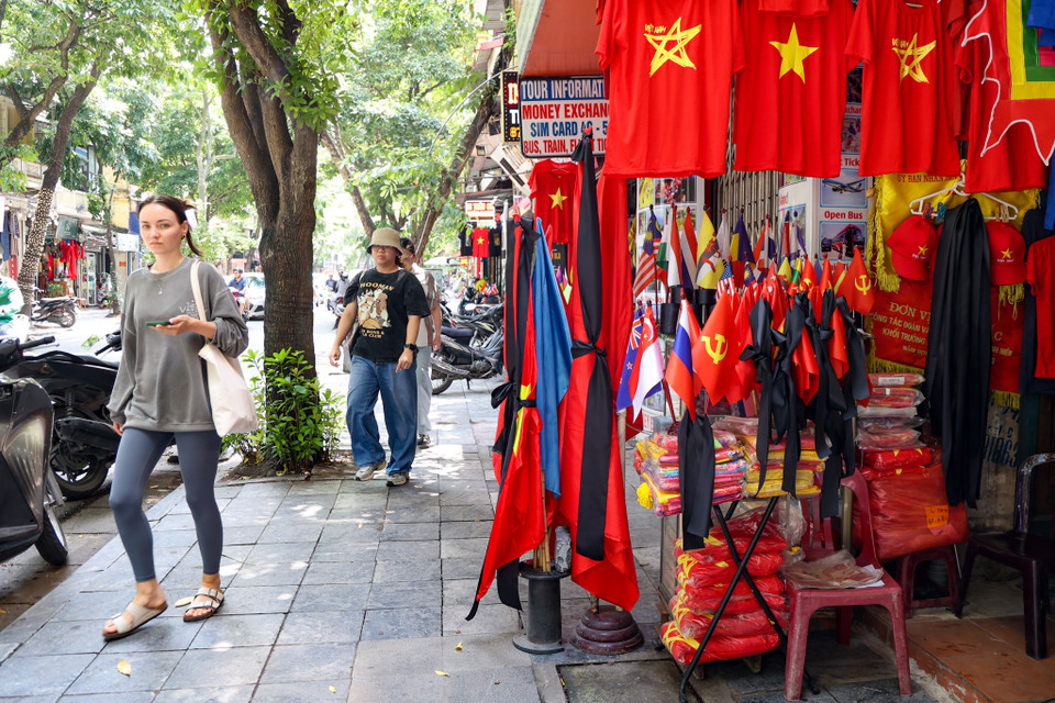 Một tiệm bán cờ trên phố Hàng Bông đang bày bán những lá cờ kèm băng quấn đen để bán cho khách. (Ảnh: Minh Hiếu/Vietnam+)