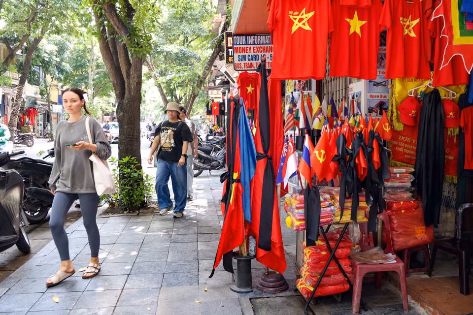 Một tiệm bán cờ trên phố Hàng Bông đang bày bán những lá cờ kèm băng quấn đen để bán cho khách. (Ảnh: Minh Hiếu/Vietnam+)