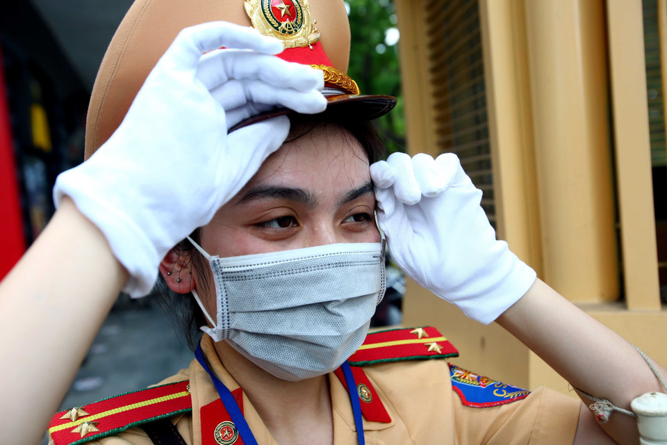 Nữ chiến sỹ cảnh sát giao thông khá vất vả khi làm việc dưới trời nắng nóng. (Ảnh: Phạm Kiên/TTXVN)