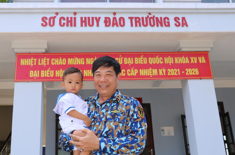 Công dân nhí Lâm Nhật Kiến Huy (18 tháng tuổi) cùng Chuẩn Đô đốc Phan Tuấn Hùng - Phó Tư lệnh Quân chủng Hải quân, tại thị trấn Trường Sa. (Ảnh: Sỹ Tuyên/TTXVN)