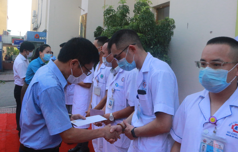 Lãnh đạo ngành y tế tỉnh Quảng Ninh tặng hoa, quà cho các y, bác sỹ tham gia chi viện cho Bắc Giang đợt 2. (Ảnh: Thanh Vân/TTXVN)