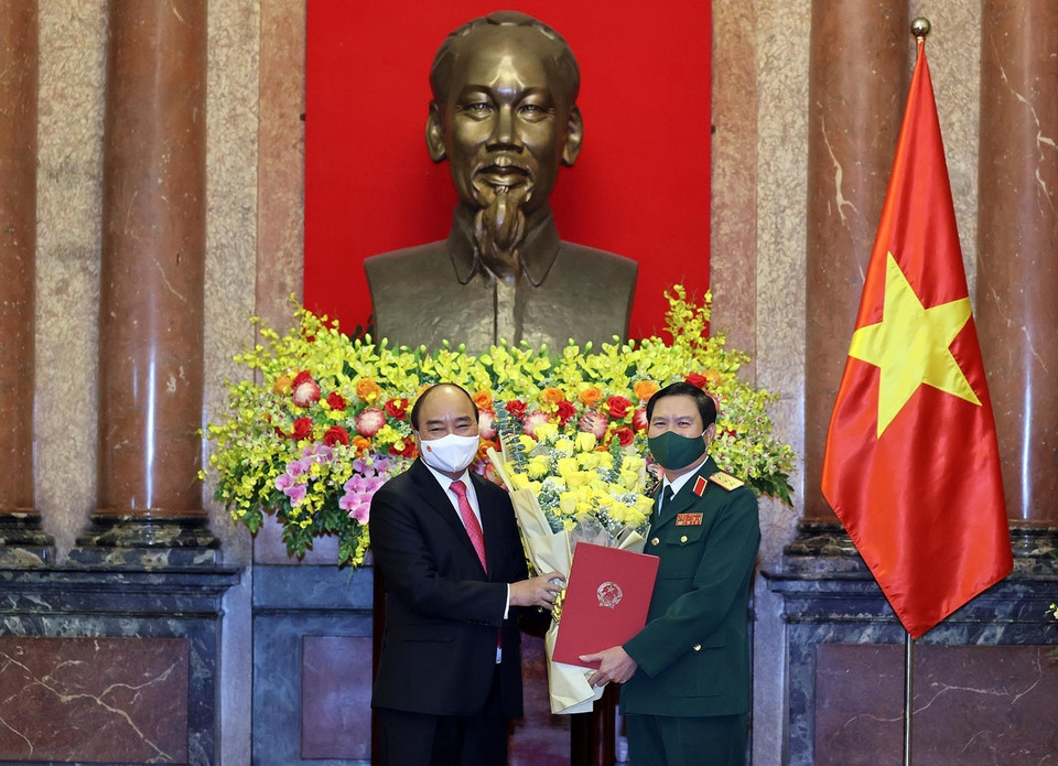 Chủ tịch nước Nguyễn Xuân Phúc tặng hoa chúc mừng Thượng tướng Nguyễn Tân Cương. (Ảnh: Thống Nhất/TTXVN)