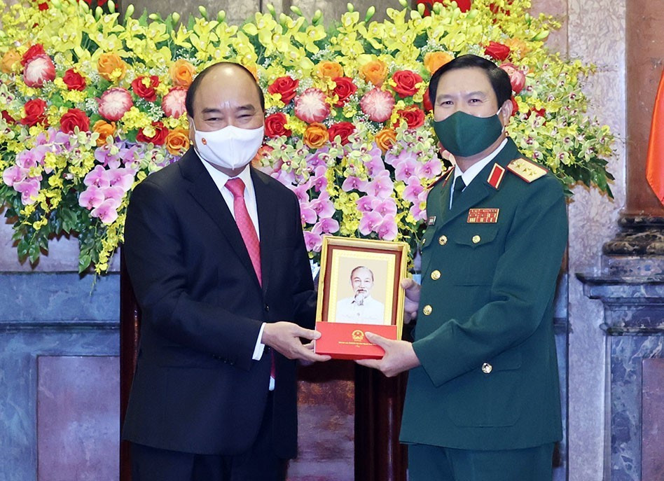 Chủ tịch nước Nguyễn Xuân Phúc tặng chân dung Chủ tịch Hồ Chí Minh cho Thượng tướng Nguyễn Tân Cương. (Ảnh: Thống Nhất/TTXVN)