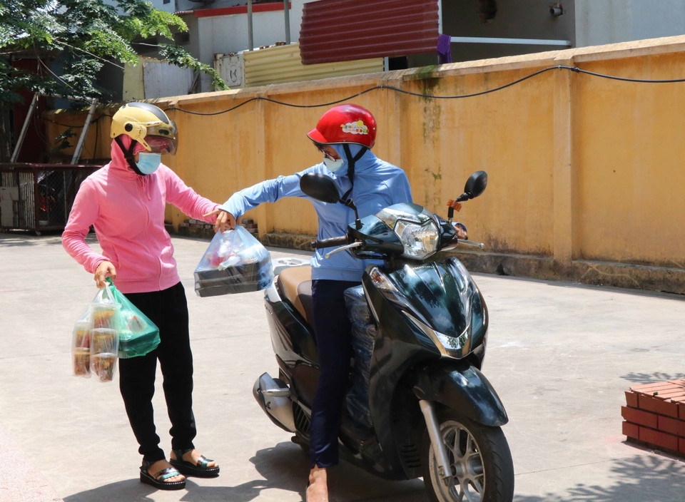 Phụ nữ phường Vũ Ninh, thành phố Bắc Ninh đi đưa cơm cho lực lượng tuyến đầu chống dịch. (Ảnh: Thanh Thương/TTXVN)