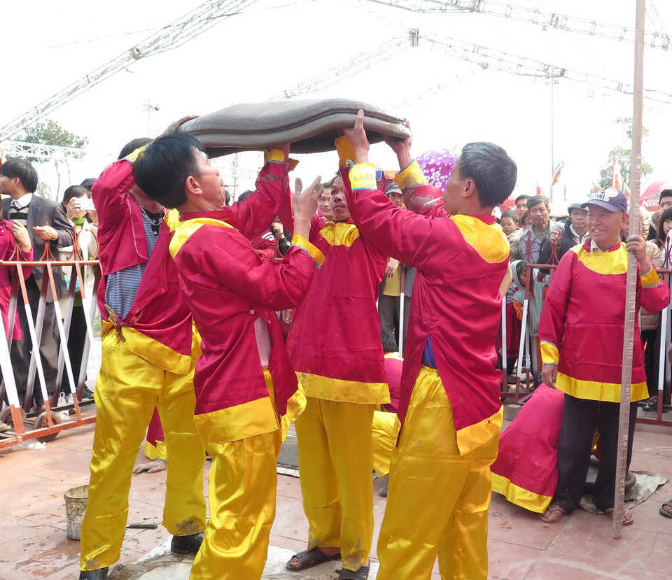 Đôi khi cần nhiều người nâng quả pháo đất lấy đà trước khi ném để tạo tiếng nổ vang. (Ảnh: Xuân Tiến/TTXVN)