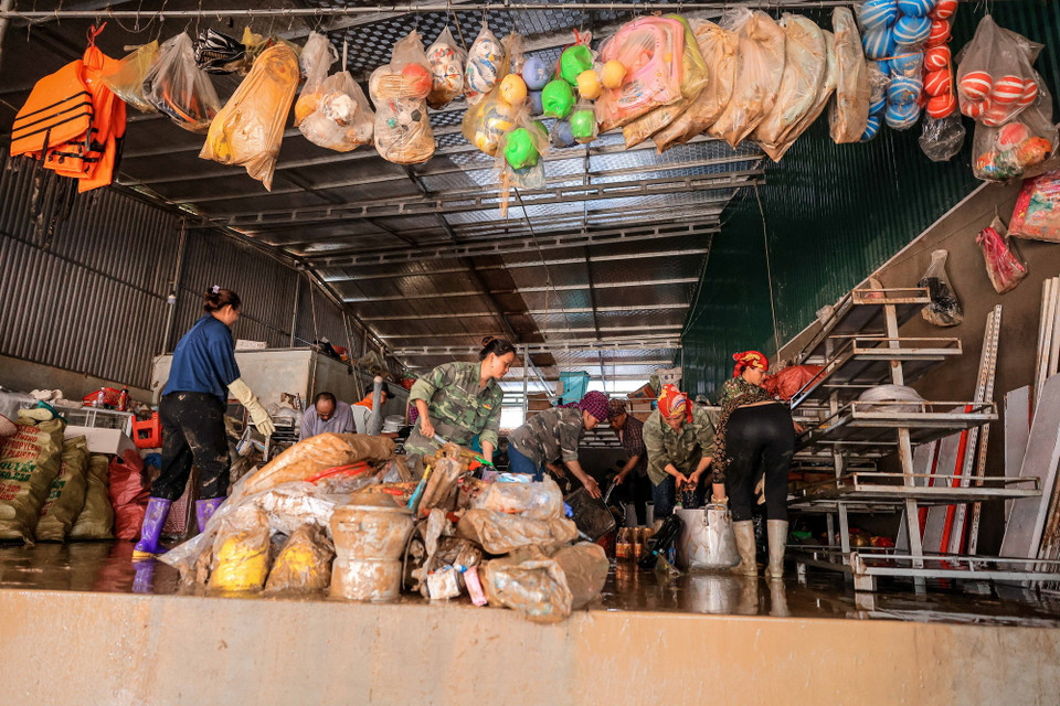 Nước lũ cùng bùn đất dâng cao khiến hàng hoá của các hộ kinh doanh ở xã Phúc Khánh ven Quốc lộ 70 bị hư hỏng nặng, không thể sử dụng. (Ảnh: Hoàng Hiếu/TTXVN)