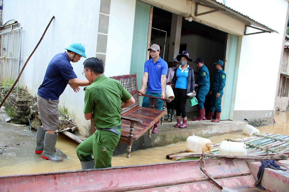 Các lực lượng di chuyển vật dụng gia đình giúp nhân dân bản Phé, xã Tông Cọ đến nơi an toàn. (Ảnh: Quang Quyết/TTXVN)