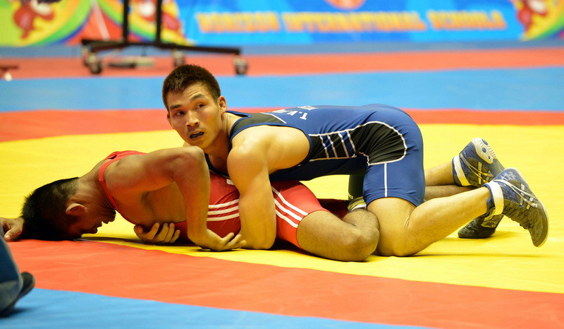 Trần Văn Tưởng (áo xanh) đấu với Rus Tang (Indonesia) ở hạng 66kg. (Ảnh: Thanh Hà/TTXVN)