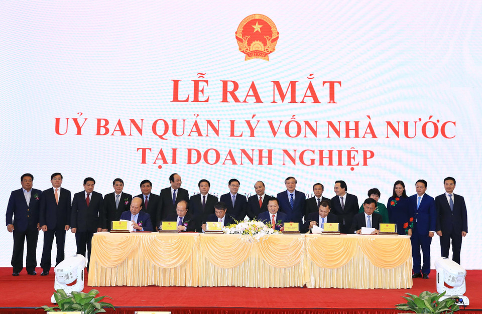 Thủ tướng Nguyễn Xuân Phúc và các đại biểu chứng kiến Lễ ký kết biên bản ghi nhớ giữa Ủy ban quản lý vốn nhà nước tại doanh nghiệp và 5 Bộ về kế hoạch chuyển giao các công việc và chuyển giao hồ sơ các doanh nghiệp về Ủy ban. (Ảnh: Thống Nhất/TTXVN)