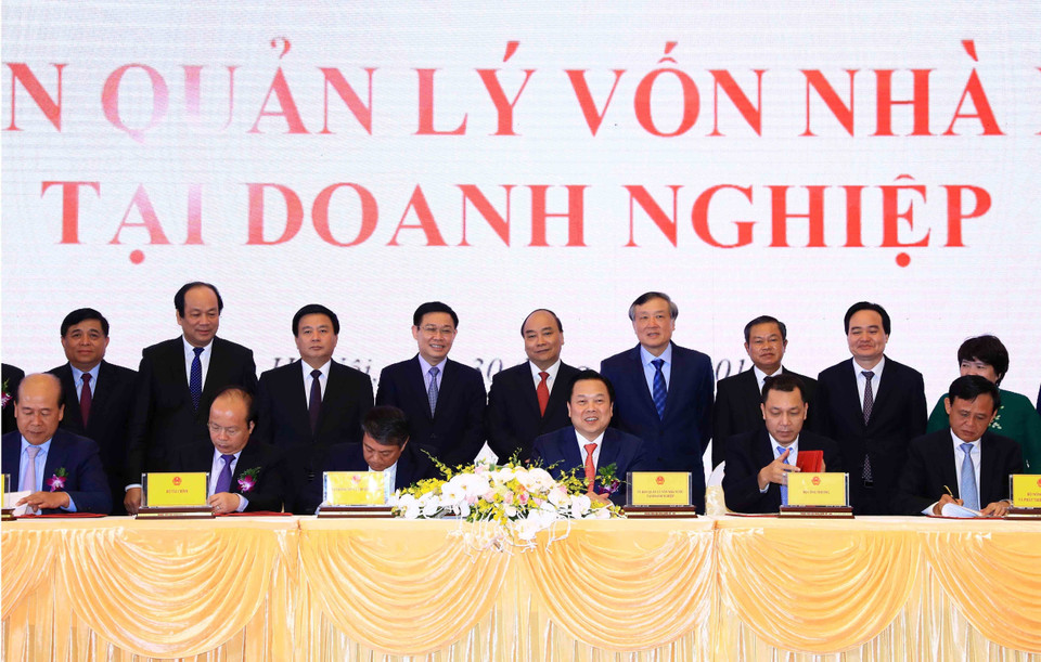 Thủ tướng Nguyễn Xuân Phúc và các đại biểu chứng kiến Lễ ký kết biên bản ghi nhớ giữa Ủy ban quản lý vốn nhà nước tại doanh nghiệp và 5 Bộ về kế hoạch chuyển giao các công việc và chuyển giao hồ sơ các doanh nghiệp về Ủy ban. (Ảnh: Thống Nhất/TTXVN)