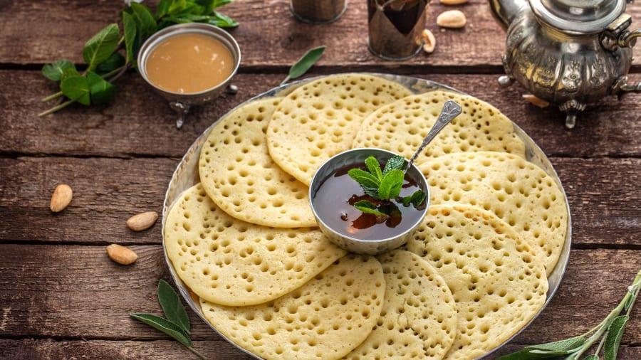 MAROC: Cùng với trà bạc hà, bánh từ bột mì cứng semolina là món ăn chủ đạo trong bữa sáng của người Maroc. Bánh baghrir là những lát bánh tròn mỏng, được đục thêm những lỗ nhỏ khiến chúng có tên 'bánh kếp nghìn lỗ' được phủ bơ và mật ong. Còn harcha là những chiếc bánh quy dầy hơn, hình tròn, giòn rụ, ăn kèm bơ, mứt và mật ong. (Nguồn: CNN)