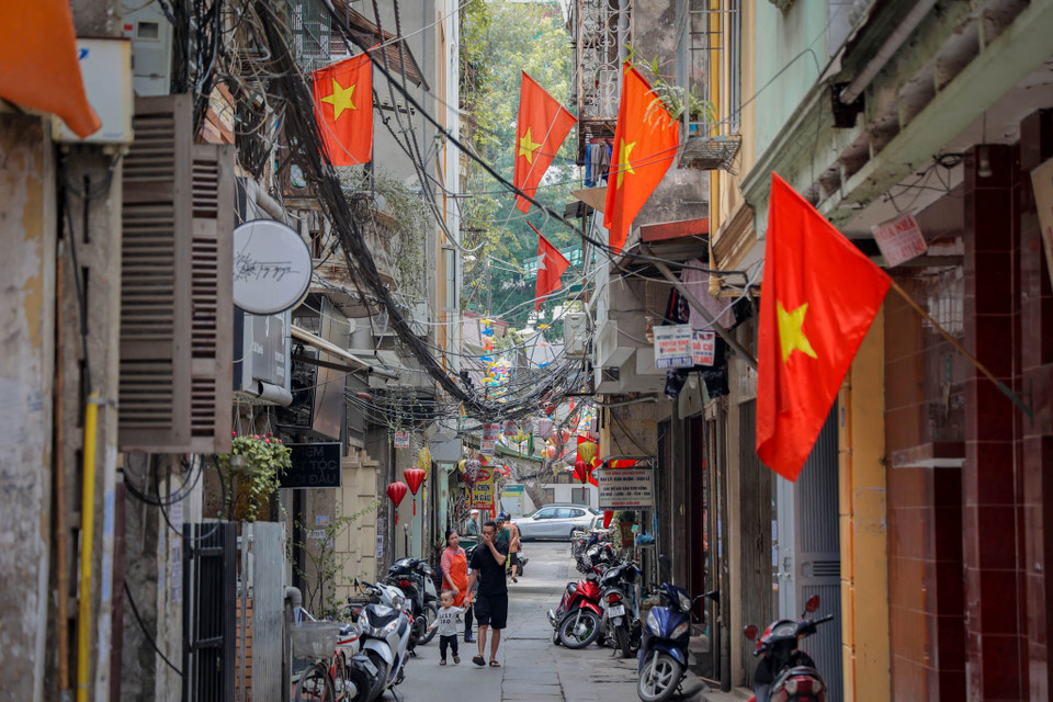 Người dân tại phố Cảm Hội (Hà Nội) treo cờ Tổ quốc trước nhà để kỷ niệm những tháng ngày lịch sử của dân tộc. (Ảnh: Minh Hiếu/Vietnam+)