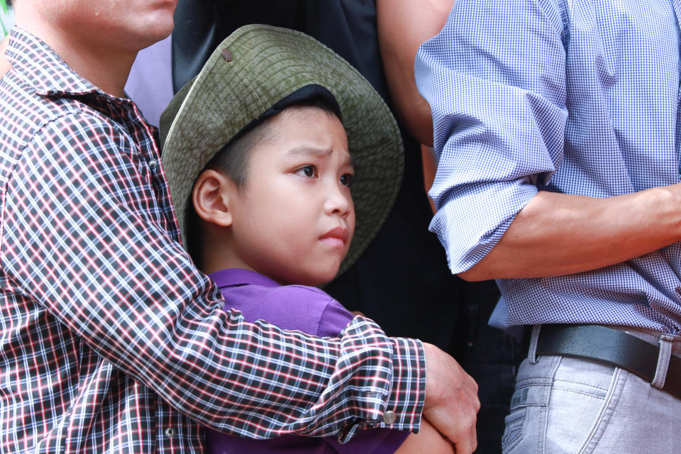 Số lượng cổ động viên quá đông khiến việc xếp hàng trở nên chen chúc và đùn đẩy. Nhiều em nhỏ vì thế bị xô theo dòng người dù được người thân che chắn.