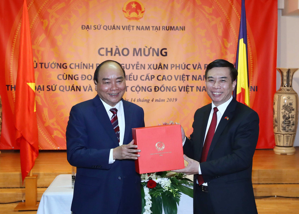 Thủ tướng Nguyễn Xuân Phúc tặng quà lưu niệm cho cán bộ nhân viên Đại sứ quán và cộng đồng người Việt Nam tại Romania. (Ảnh: Thống Nhất/TTXVN)