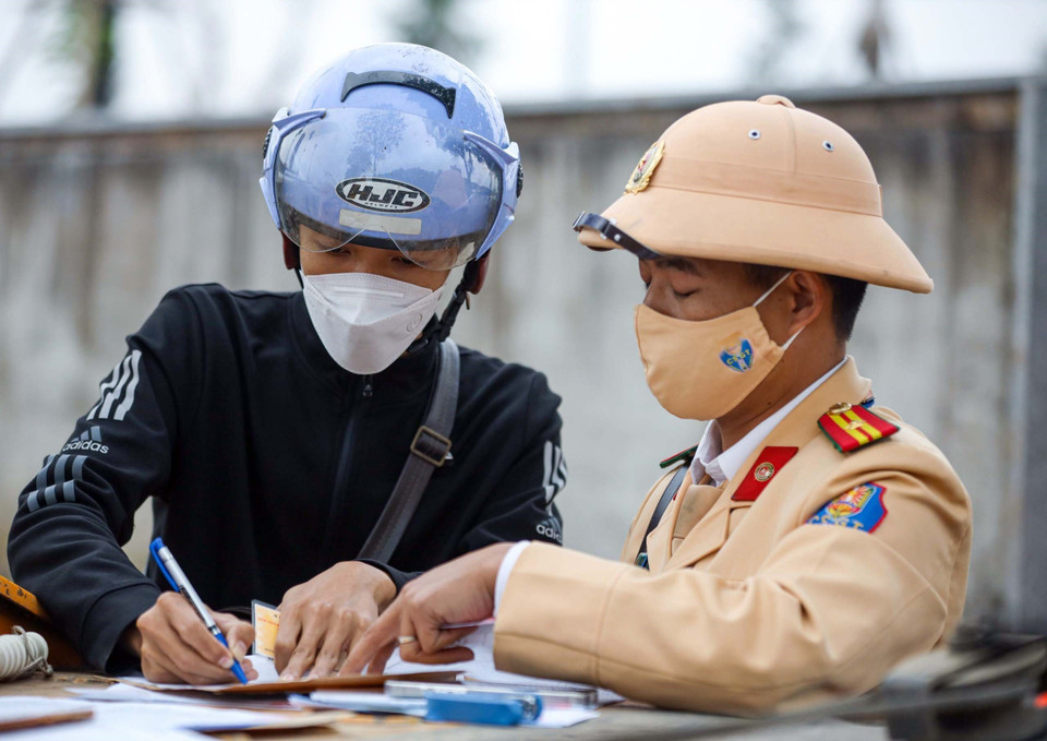 Cán bộ, chiến sỹ đội Cảnh sát Giao thông số 11 lập biên bản, xử lý với tài xế xe máy đi vào cao tốc Đại lộ Thăng Long. (Ảnh: Phạm Kiên/TTXVN)