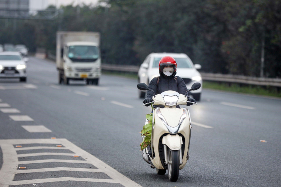 Người dân điều khiển xe máy bất chấp nguy hiểm đi vào cao tốc Đại lộ Thăng Long. (Ảnh: Phạm Kiên/TTXVN)