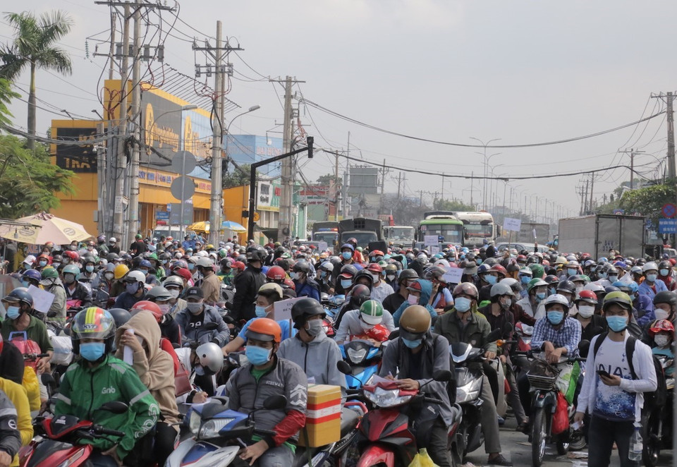 Hàng nghìn người dân tập trung ở khu vực Quốc lộ 1 đoạn qua Thị trấn Tân Túc, huyện Bình Chánh, Thành phố Hồ Chí Minh. (Ảnh: TTXVN phát)