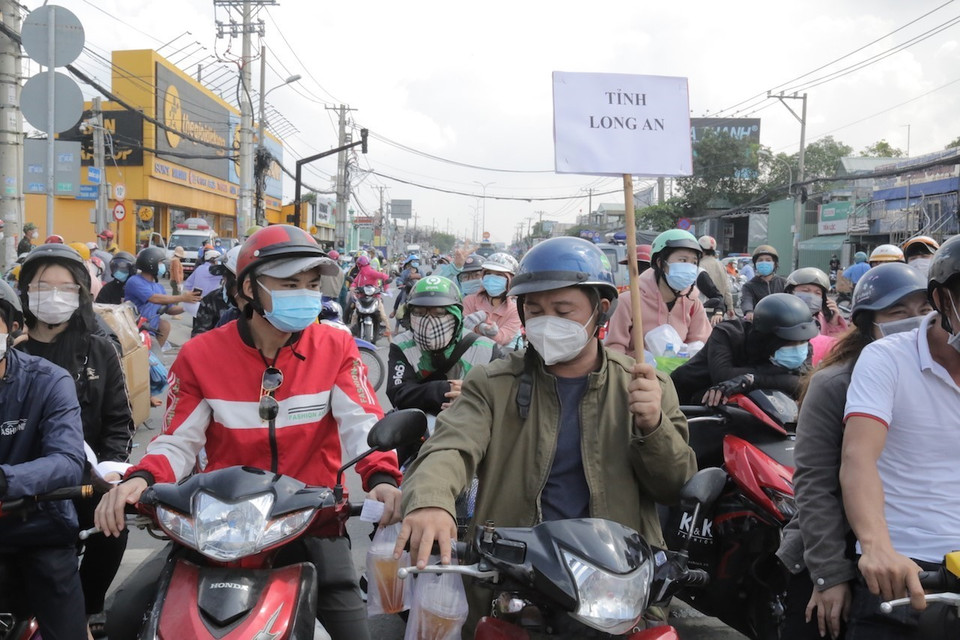 Người dân quê Long An tập trung ở khu vực Quốc lộ 1 đoạn qua Thị trấn Tân Túc, huyện Bình Chánh, Thành phố Hồ Chí Minh. (Ảnh: TTXVN phát)
