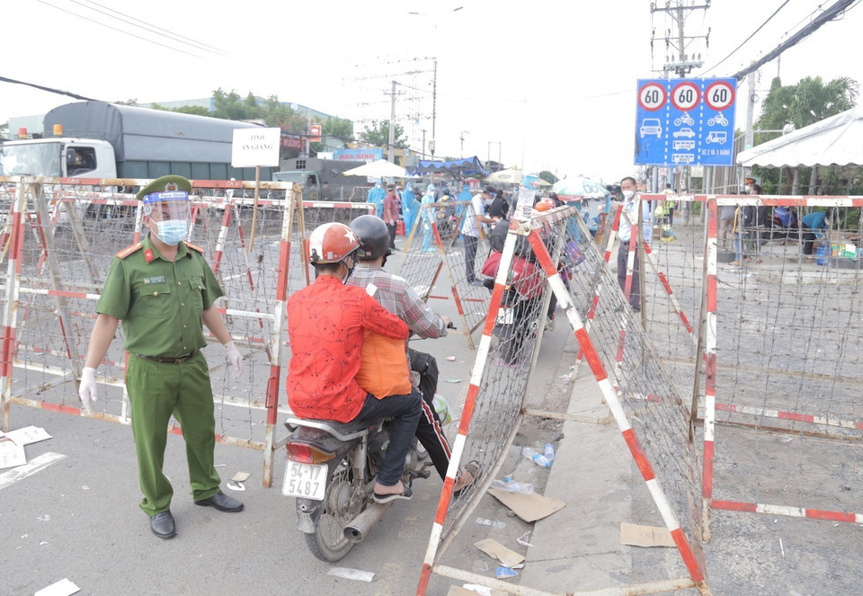 Lực lượng công an phân luồng, đảm bảo an ninh trật tự tại khu vực người dân tập trung trên Quốc lộ 1, đoạn qua Thị trấn Tân Túc, huyện Bình Chánh, Thành phố Hồ Chí Minh. (Ảnh: TTXVN phát)