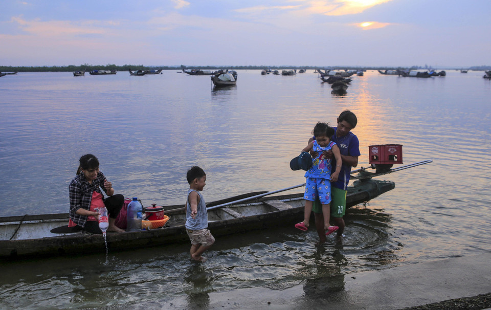 Một gia đình ngư dân trở về sau một đêm đánh bắt thủy sản trên đầm phá. (Ảnh: Hồ Cầu/TTXVN)