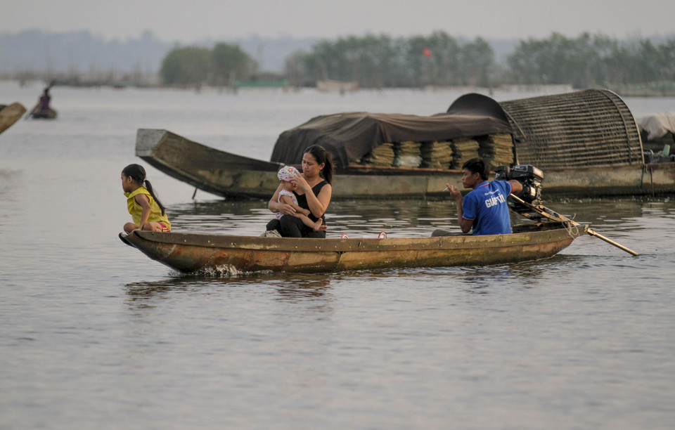 Một gia đình ngư dân trở về sau một đêm đánh bắt thủy sản trên đầm phá. (Ảnh: Hồ Cầu/TTXVN)