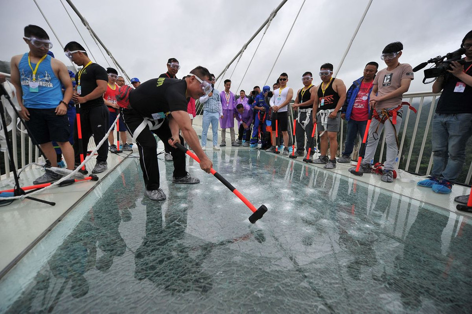 Các du khách cầm búa tạ và cố gắng đập mạnh vào cầu. (Nguồn: IMAGINECHINA)