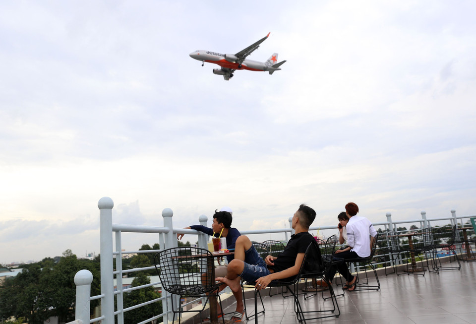 Thường sau 3 giờ chiều sẽ có rất đông khách đến quán càphê sân thượng chọn cho mình một chỗ ngồi lý tưởng để thoải mái nhìn ngắm máy bay. (Ảnh: Huy Hùng/TTXVN)