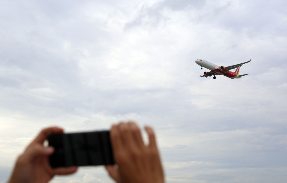 Ngồi tại quán càphê người dân có thể chụp được những bức ảnh máy bay hạ cánh với cự ly rất gần. (Ảnh: Huy Hùng/TTXVN)