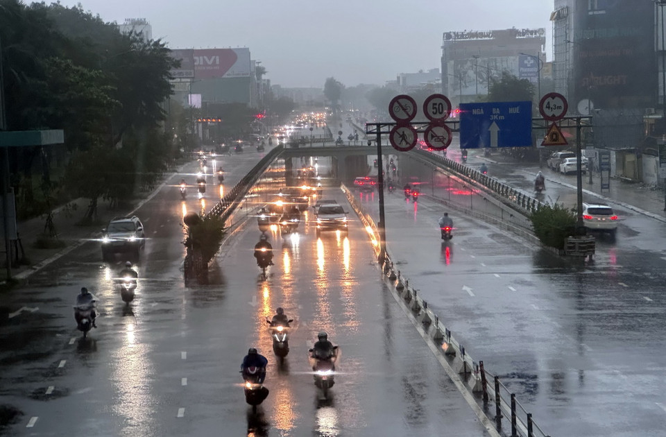 Mưa ngập vào sáng sớm khiến nhiều người phải dắt xe máy đi làm. (Ảnh: Quốc Dũng/TTXVN)