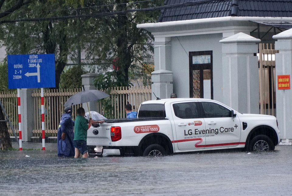 Xe ôtô bị ngập nước, chết máy được người dân đẩy lên vỉa hè. (Ảnh: Quốc Dũng/ TTXVN)