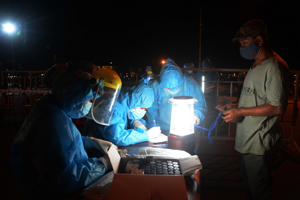 Lấy mẫu xét nghiệm cho người dân Cảng cá Thọ Quang. (Ảnh: Văn Dũng/TTXVN)