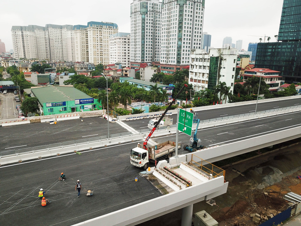Đến nay, các hạng mục trải thảm nhựa đường, lắp đặt hệ thống đèn cao áp biển báo, sơn kẻ đường, lan can hộ làn cũng đang được đơn vị gấp rút hoàn thiện. (Ảnh: Hào Nguyễn/Vietnam+)