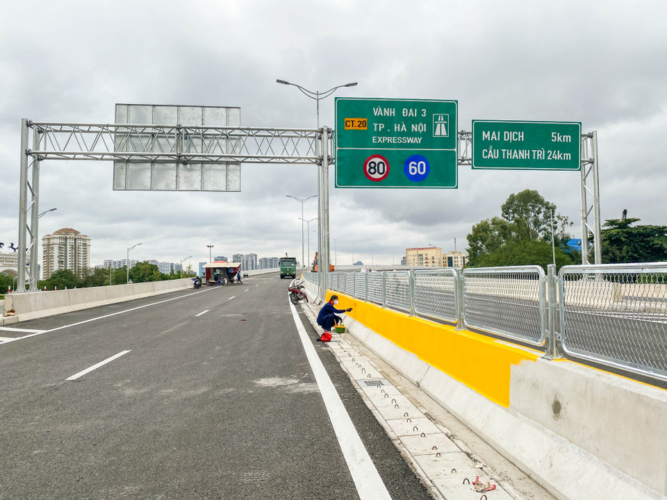 Công nhân đang hoàn thiện công việc sơn lan can cầu. (Ảnh: Hào Nguyễn/Vietnam+)