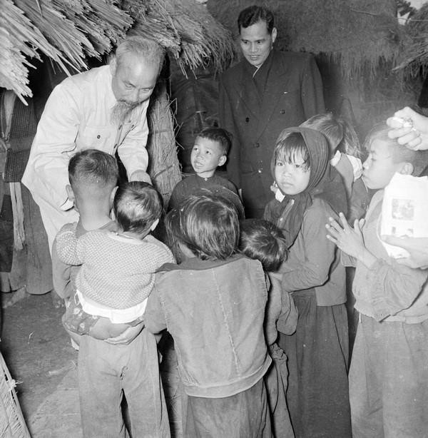 Bác Hồ đến thăm, ân cần hỏi chuyện con em gia đình có công với cách mạng ở thôn Phú Gia, xã Phú Thượng, Tây Hồ, Hà Nội (1955). (Nguồn: TTXVN)