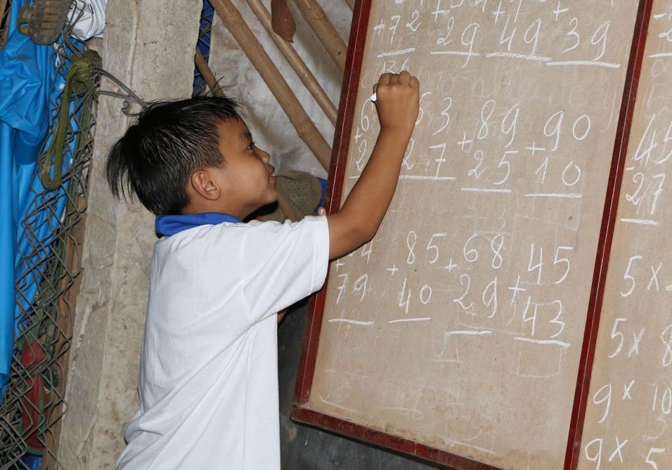 Học sinh Ngô Quốc Nam hăng say làm bài tập cô giáo đề ra. 