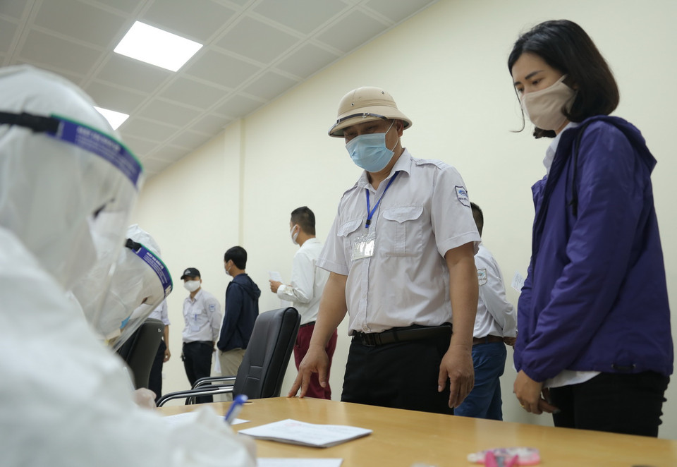 Công nhân viên Bến xe Giáp Bát khai báo y tế để xét nghiệm COVID-19. (Ảnh: Hoàng Hiếu/TTXVN)