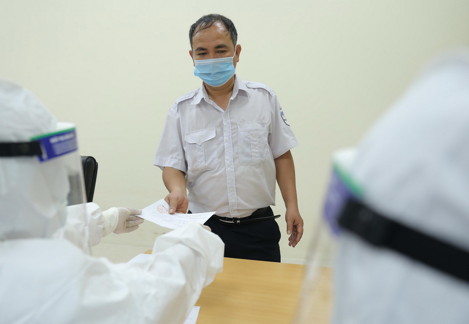 Công nhân viên Bến xe Giáp Bát khai báo y tế để xét nghiệm COVID-19. (Ảnh: Hoàng Hiếu/TTXVN)