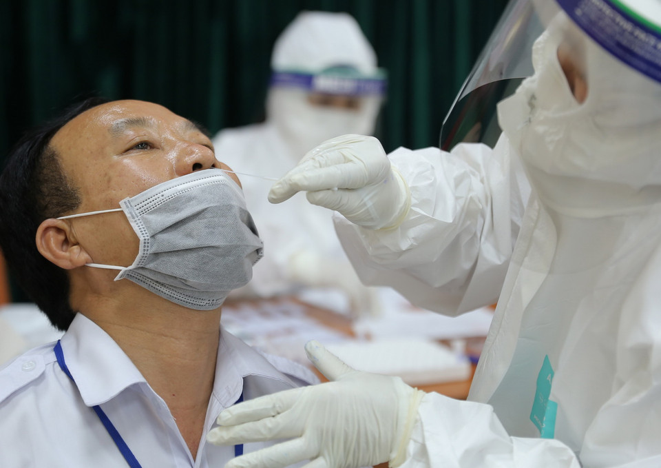 Lấy mẫu xét nghiệm COVID-19 cho công nhân viên Bến xe Giáp Bát. (Ảnh: Hoàng Hiếu/TTXVN)