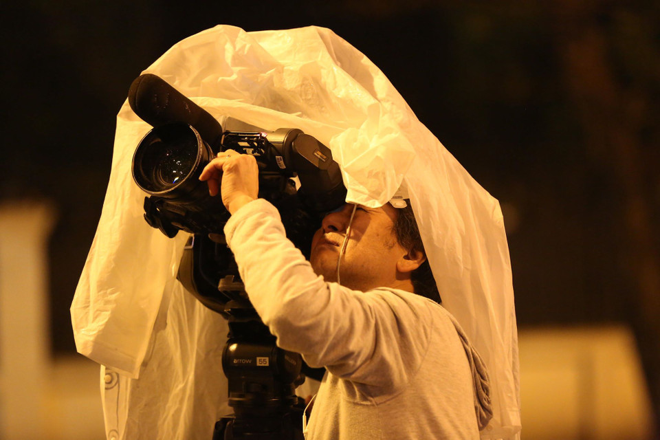 Che mưa cho thiết bị và đã sẵn sàng để có những khuôn hình đầu tiên. (Ảnh: Minh Sơn/Vietnam+)